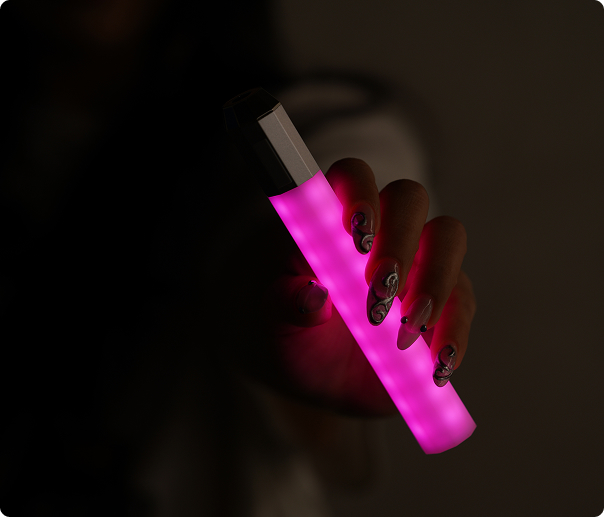 A Litsaber glowing fuchsia, held in one hand against a dark background